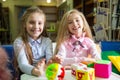 Two funny girls playing with alphabet blocks in library Royalty Free Stock Photo