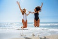 Two funny girls in swimsuit jumping on a tropical beach Royalty Free Stock Photo