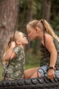 two funny girls swing on a swing Royalty Free Stock Photo