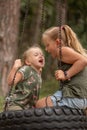 two funny girls swing on a swing