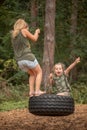 two funny girls swing on a swing Royalty Free Stock Photo