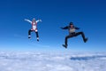 Two funny guys are falling above white clouds. Royalty Free Stock Photo