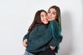 Two funny happy women girl friends embrace on white background. women`s friendship, sisters, youth