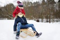 Two funny little girls having fun with a sleigh in beautiful winter park. Cute children playing in a snow. Royalty Free Stock Photo