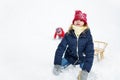 Two funny little girls having fun with a sleigh in beautiful winter park. Cute children playing in a snow. Royalty Free Stock Photo