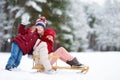 Two funny little girls having fun with a sleight in beautiful winter park. Cute children playing in a snow. Royalty Free Stock Photo