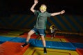 Two funny looking boys playing superhero, jumping on trampoline with run up