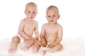 Two funny lovely baby boys sitting together on white background