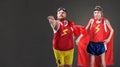 Two funny men in suits of superheroes. Thin and fat people Royalty Free Stock Photo