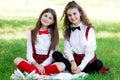 Two funny schoolgirls sit on the grass and read books. Girls, girlfriends, sisters are taught lessons in nature Royalty Free Stock Photo