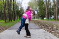 Two funny siblings sister hugging with each other while walk in park. Having fun together, positive emotions