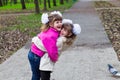 Two funny siblings sister hugging with each other while walk in park. Having fun together, positive emotions