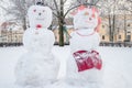 Two funny snow figures - a snowman and a woman Royalty Free Stock Photo