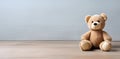 Two funny teddy bears on the floor of a room sitting near the wall.