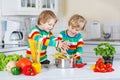 Two funny twin kids cooking italian meal with spahetti
