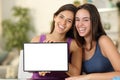 Two funny women showing blank tablet screen Royalty Free Stock Photo