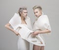 Two futuristic blonde women in white outfit