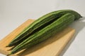 Two gambas or oyong or luffa gourd fruits on a wooden cutting board Royalty Free Stock Photo