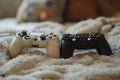 Two gaming controllers rest on a cozy blanket in a living room setting, inviting a night of gaming fun and relaxation Royalty Free Stock Photo
