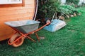 Two garden wheelbarrows near wooden wall