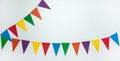 Two garlands of multi-colored triangle paper flags on a white background. Royalty Free Stock Photo