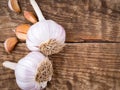 Two garlic bulbs and cloves on aged wooden table. Royalty Free Stock Photo