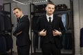 Two gay friends in classic vest against row of suits in shop