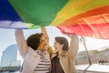 Two gay girls laughing with rainbow flag