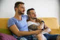 Two gay men on sofa embracing at home Royalty Free Stock Photo