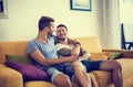 Two gay men on sofa embracing at home Royalty Free Stock Photo