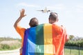 Two gay men greet a plane flying in the sky, Rainbow flag is a symbol of lesbian, gay, bisexual, and transgender.LGTB,LGBT