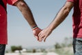 Two gay men shake hands with an LGBT bracelet.LGTB,LGBT