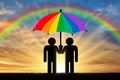 Two gay men under a rainbow umbrella