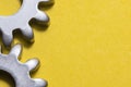 Two gears geared on a yellow background with copy space, geared steel sprockets, sprocket, background with gearing parts Royalty Free Stock Photo