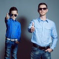 Two gentlemen: young father and his little cute son in sunglasse