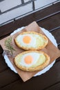 Two Georgian cheese-pies lying on a white plate. Cooked from chees, egg yolk