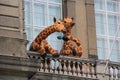 Two giant spotted giraffes drinking tea on an open balcony