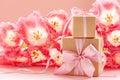 Two Gift box wrapped with craft paper and pink bow on pink flowers background Royalty Free Stock Photo