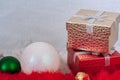 Two gift boxes and two Christmas balls on white and red fur with a white background. Royalty Free Stock Photo