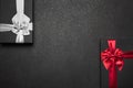 Two gift boxes with red and silver ribbons and bows on a black granite surface. Place for inscription Royalty Free Stock Photo