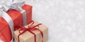 Two gift boxes with ribbons and bows on light grey background with defocused lights Royalty Free Stock Photo
