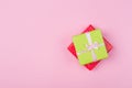 Two gift boxes wrapped in color green and red polka dots paper and tied with pink and craft ribbon on pink background