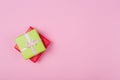 Two gift boxes wrapped in color green and red polka dots paper and tied with pink and craft ribbon on pink background