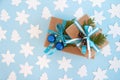 Two gift boxes wrapped of craft paper, blue and white ribbon and decorated fir branches, blue Christmas balls and pinecones. Royalty Free Stock Photo