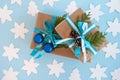 Two gift boxes wrapped of craft paper, blue and white ribbon and decorated fir branches, blue Christmas balls and pinecones. Royalty Free Stock Photo