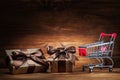 Two giftboxes and shopping cart on vintage wood