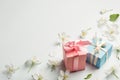 Two gifts surrounded by Apple white flowers.