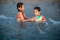 two gils in swimsuits playing with colourful ball in the sea waves Royalty Free Stock Photo