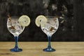 Two gin tonics on blue glass with lemon and cinnamon on wooden table Royalty Free Stock Photo