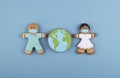 two gingerbread man medics in a mask girl and boy, gingerbread planet earth in the middle Royalty Free Stock Photo